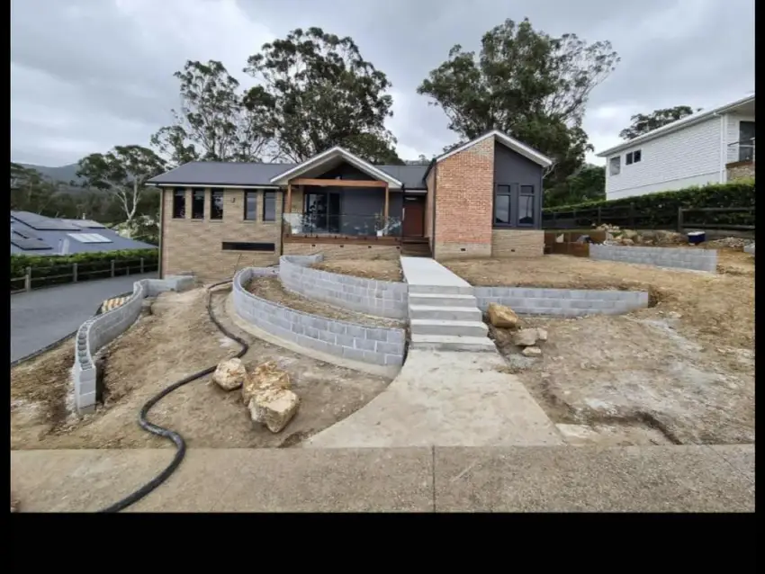 Curved paved steps and sandstone retaining leading up to a front entry.